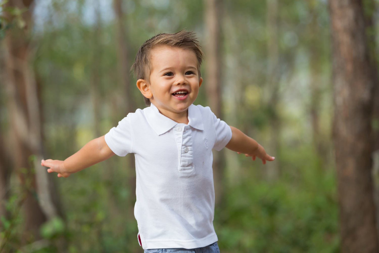 cute young boy holding arms out